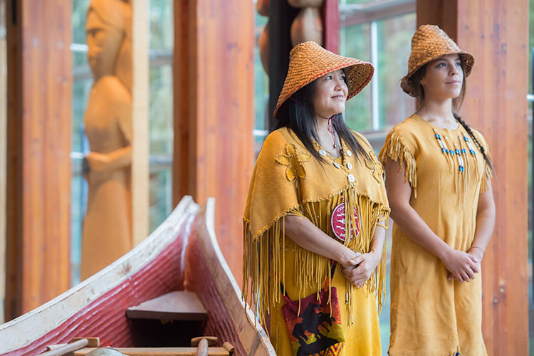 Two indigenous women look out at the forest surrounding the Squamish Lil'wat Cultural Centre.