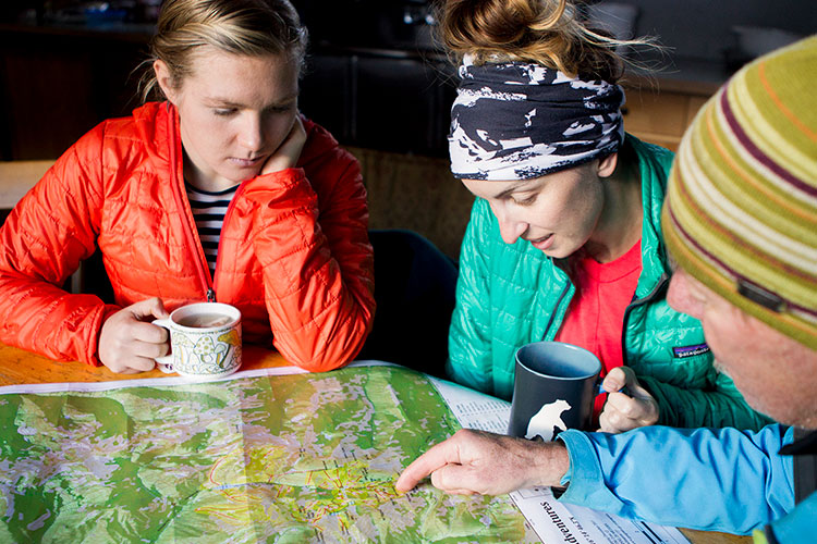 A group of three study a map to plan their trip into Whistler's backcountry.