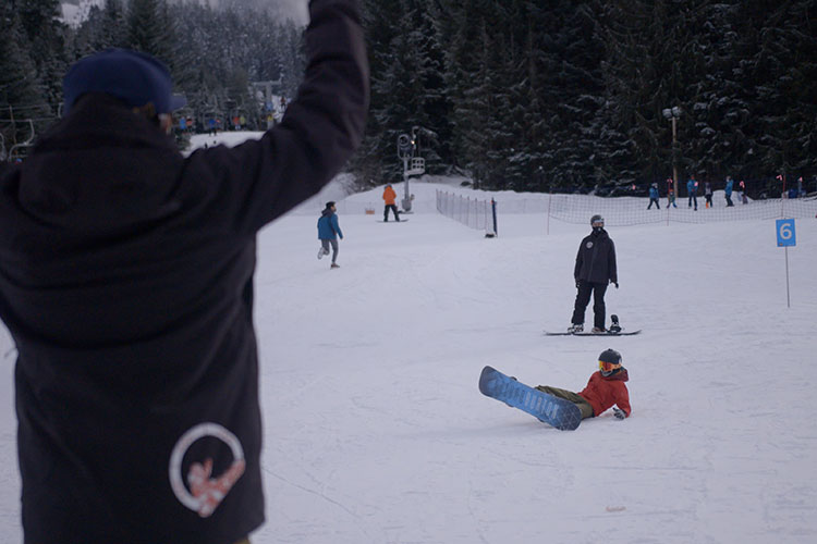 Court Larabee cheers a young snowboarder on who has just fallen over.
