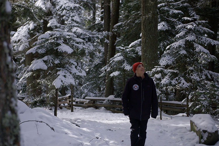 Court Larabee walks a snowy trail in the forests of Whistler.