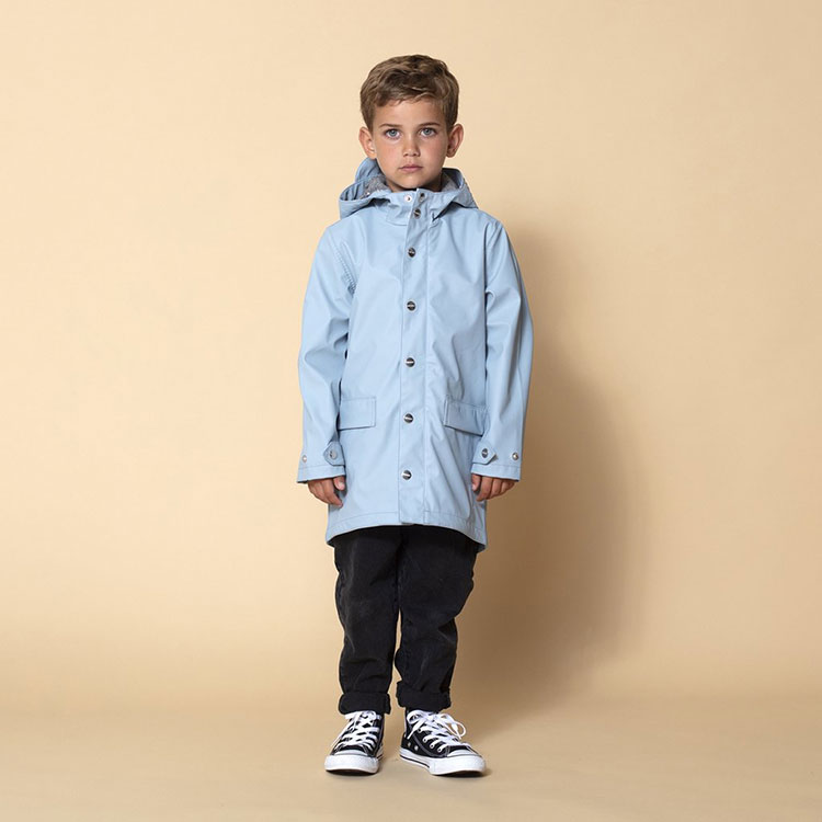 A young boy models the Lazy Geese rain jacket in blue.