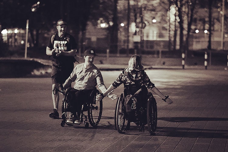 A man and woman in wheelchairs high five after completing the Wings for Life World Run.
