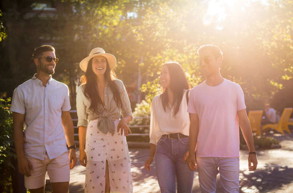 A group of friends walk down the Whistler Village Stroll on a sunny, summer's day.