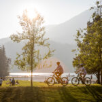 Two bikers peacefully ride through Rainbow Park on a sunny, summer's day in Whistler.