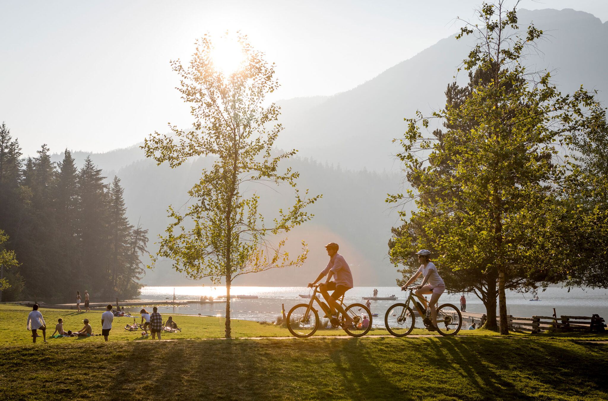Two bikers peacefully ride through Rainbow Park on a sunny, summer's day in Whistler.