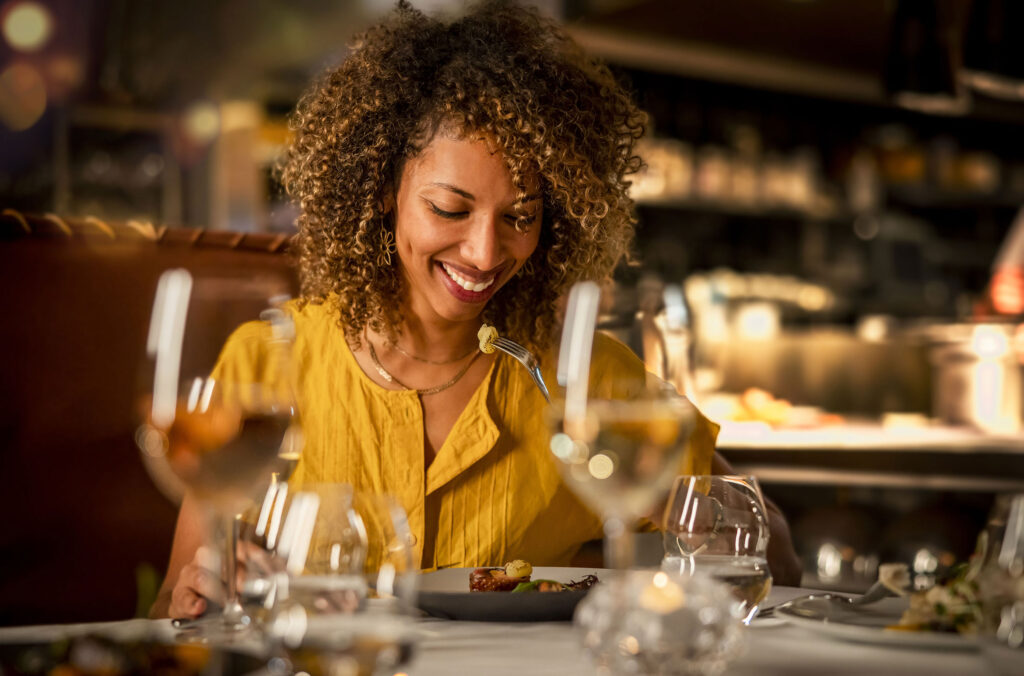 A woman enjoys her dinner at a restaurant in Whistler.