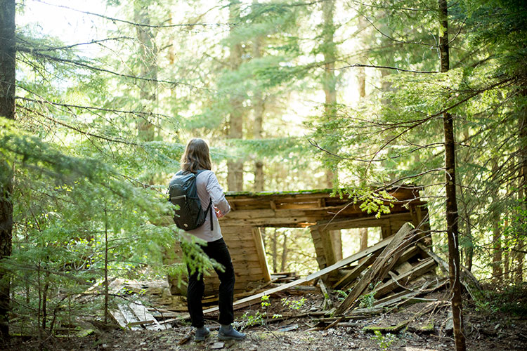 A woman looks at the remnants of an old cabin at Parkhurst in Whistler.