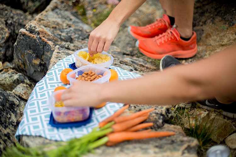 A selection of picnic nibble laid out on rocks.