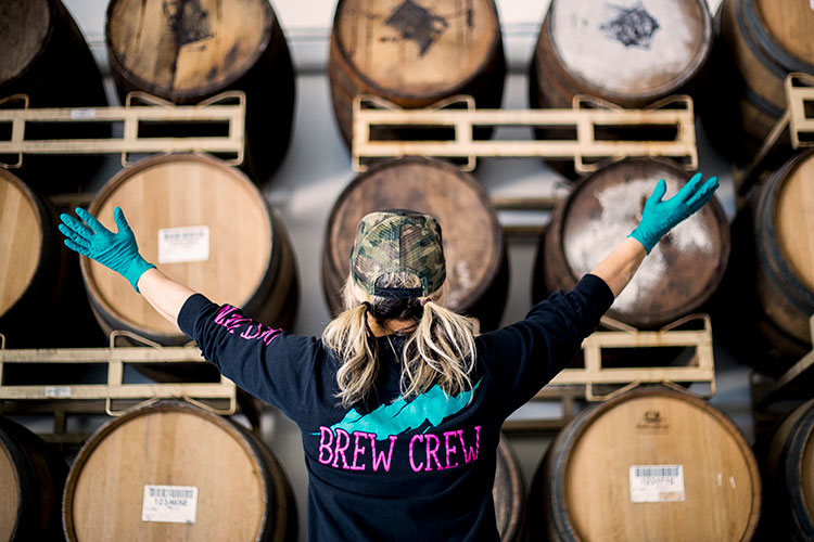 A brewer stands in front of barrels in the brewery area of Coast Mountain Brewing in Whistler.