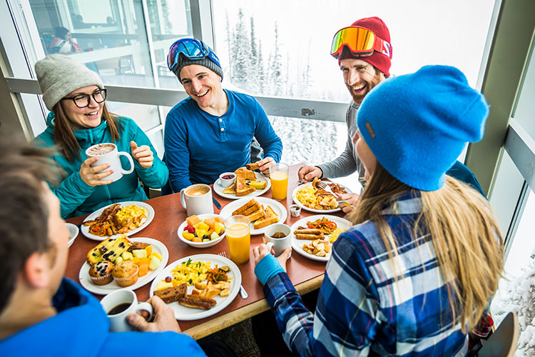 A group of friends eat at the Roundhouse on Whistler Mountain.