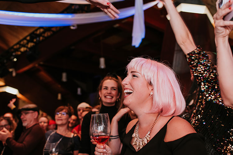 A woman laughs at an event on stage at Whistler's Cornucopia.