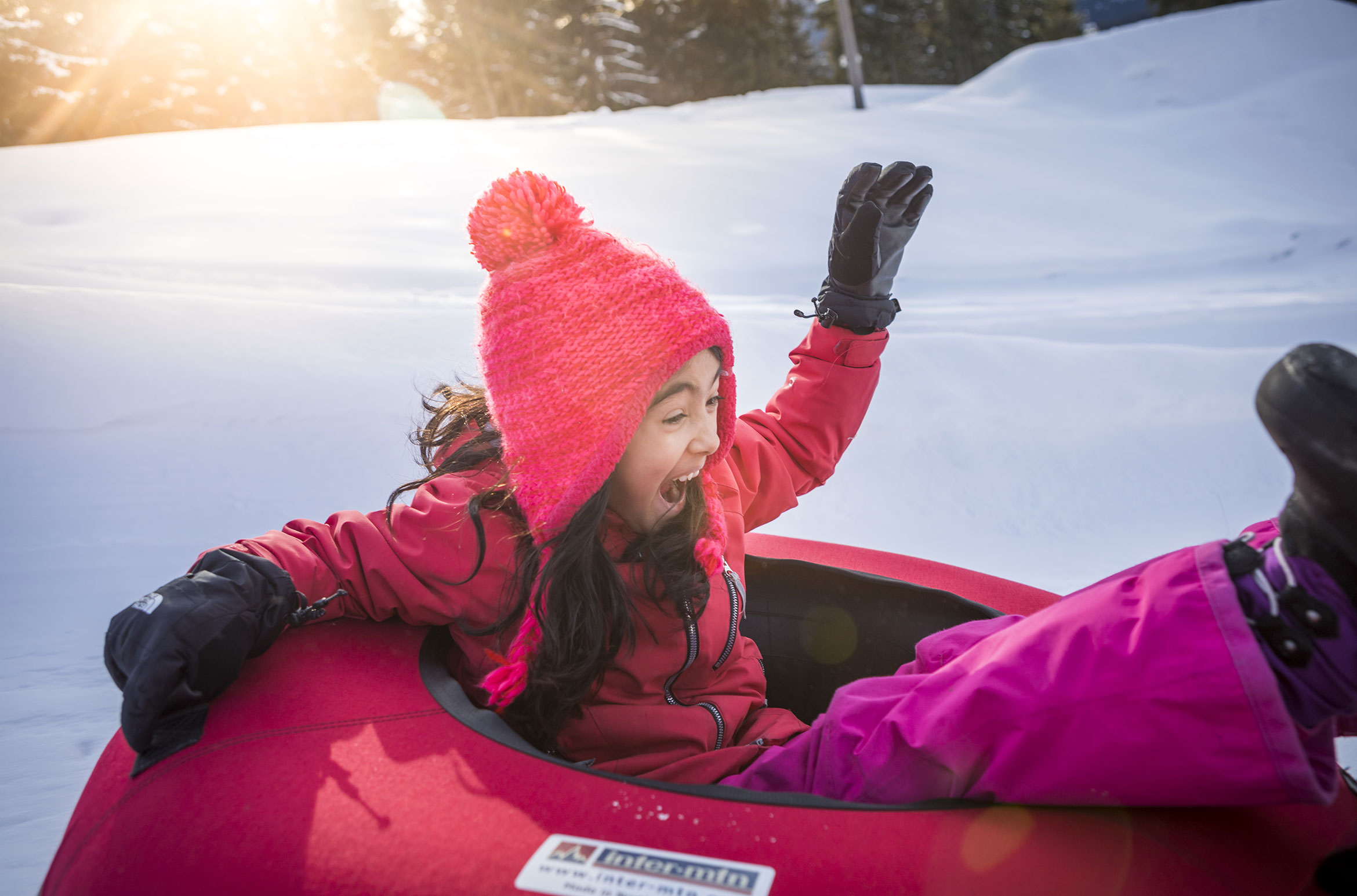 A young girl screams with delight as she slides down an icy track at the Whistler Tube Park.