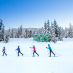 A family cross-country ski past the Olympic rings in Whistler.