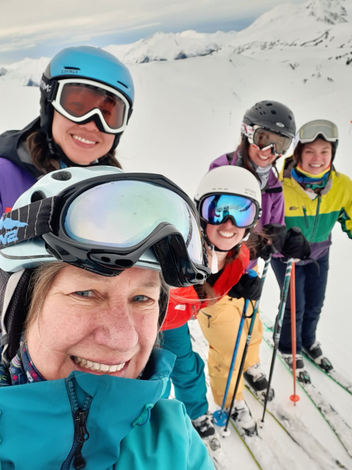 A group of skiers pose for a group shot.