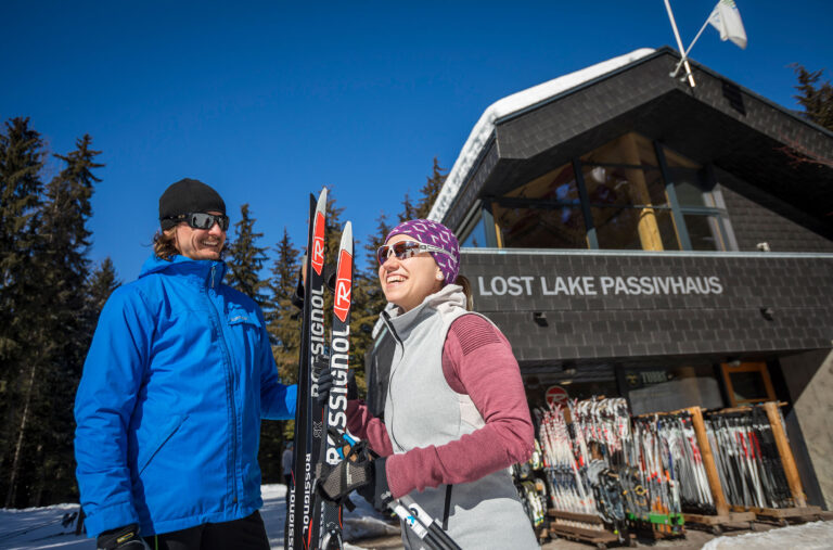 Two cross-country skiers get ready to go outside the Lost Lake PassivHaus in Whistler.