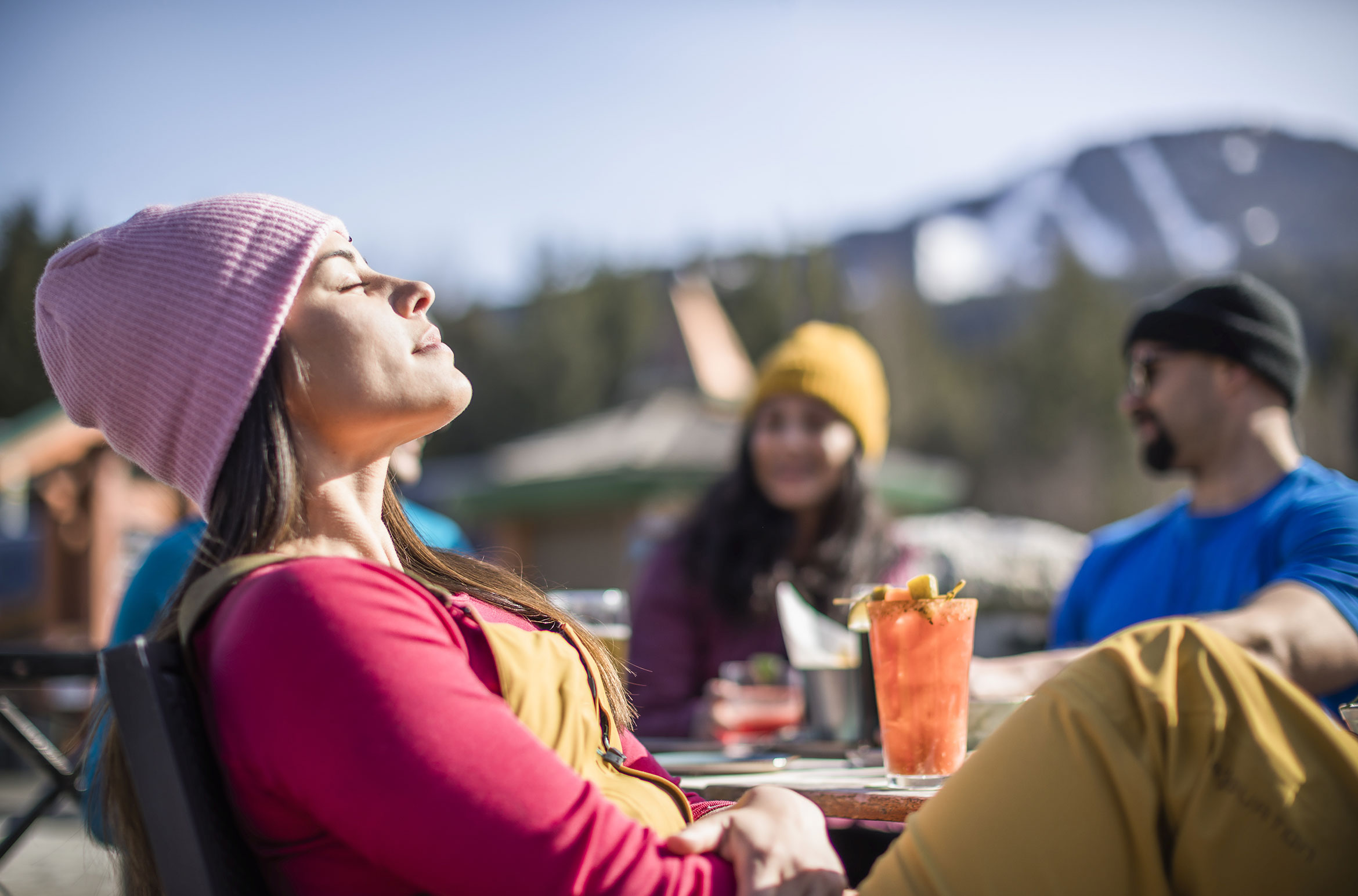 A woman enjoys the sunshine during apres in Whistler.