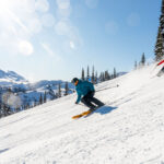 Skiers enjoy the sunshine as they ski down the slopes on Whistler Blackcomb.