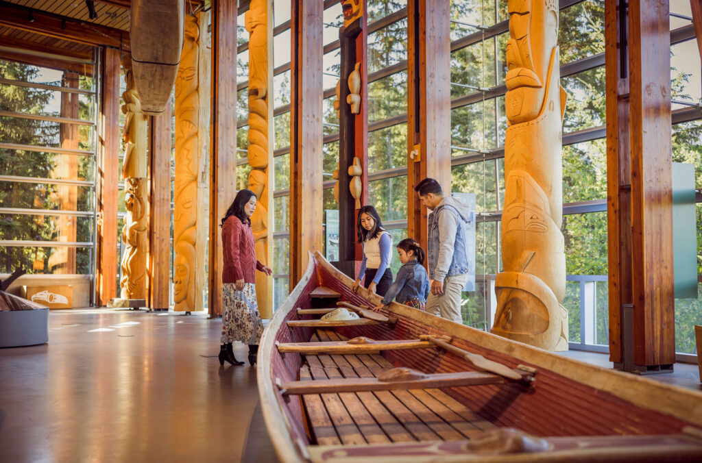 A family explore a canoe in the Main Hall of the Squamish Lil'wat Cultural Centre in Whistler.