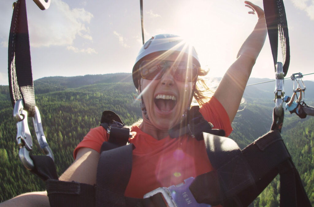 A woman ziplines across the mountains with Superfly Ziplines in Whistler.
