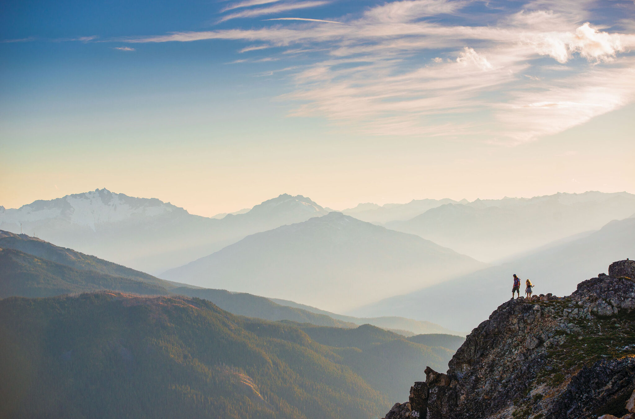 Two hikers enjoy the mountain views on Whistler Blackcomb in the summer.