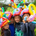 A group of young children enjoy wearing balloon crowns at the Whistler Children's Festival.