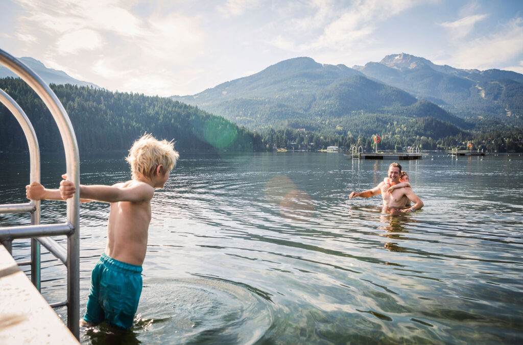 A dad and his two sons enjoy a swim in a Whistler lake.