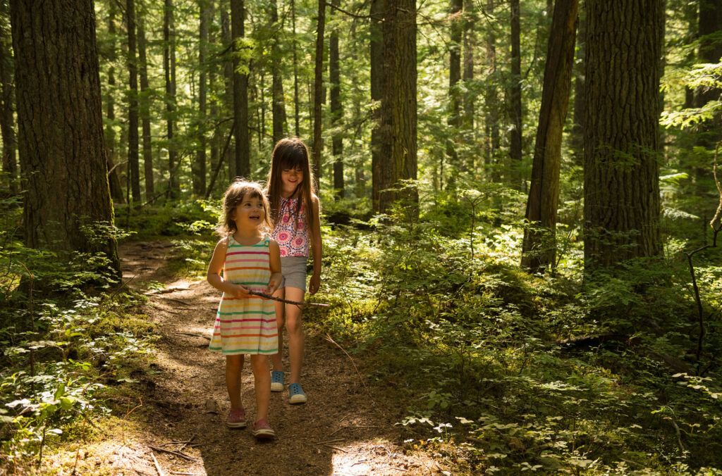 Two young children explore Whistler's forests in the summer.
