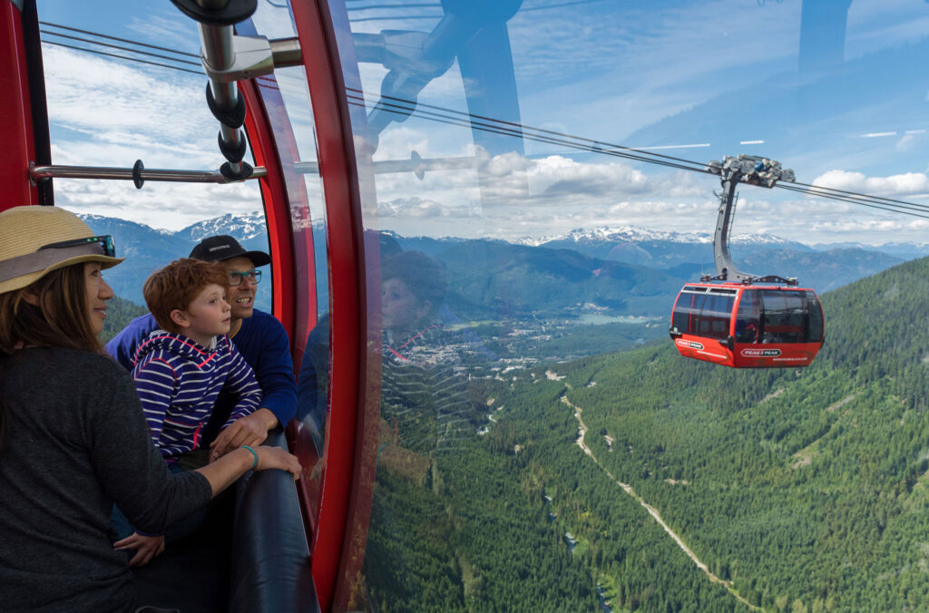 A family enjoy the PEAK 2 PEAK Gondola on Whistler Blackcomb in the summer.