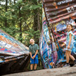 Two kids explore the train wreck in Whistler.