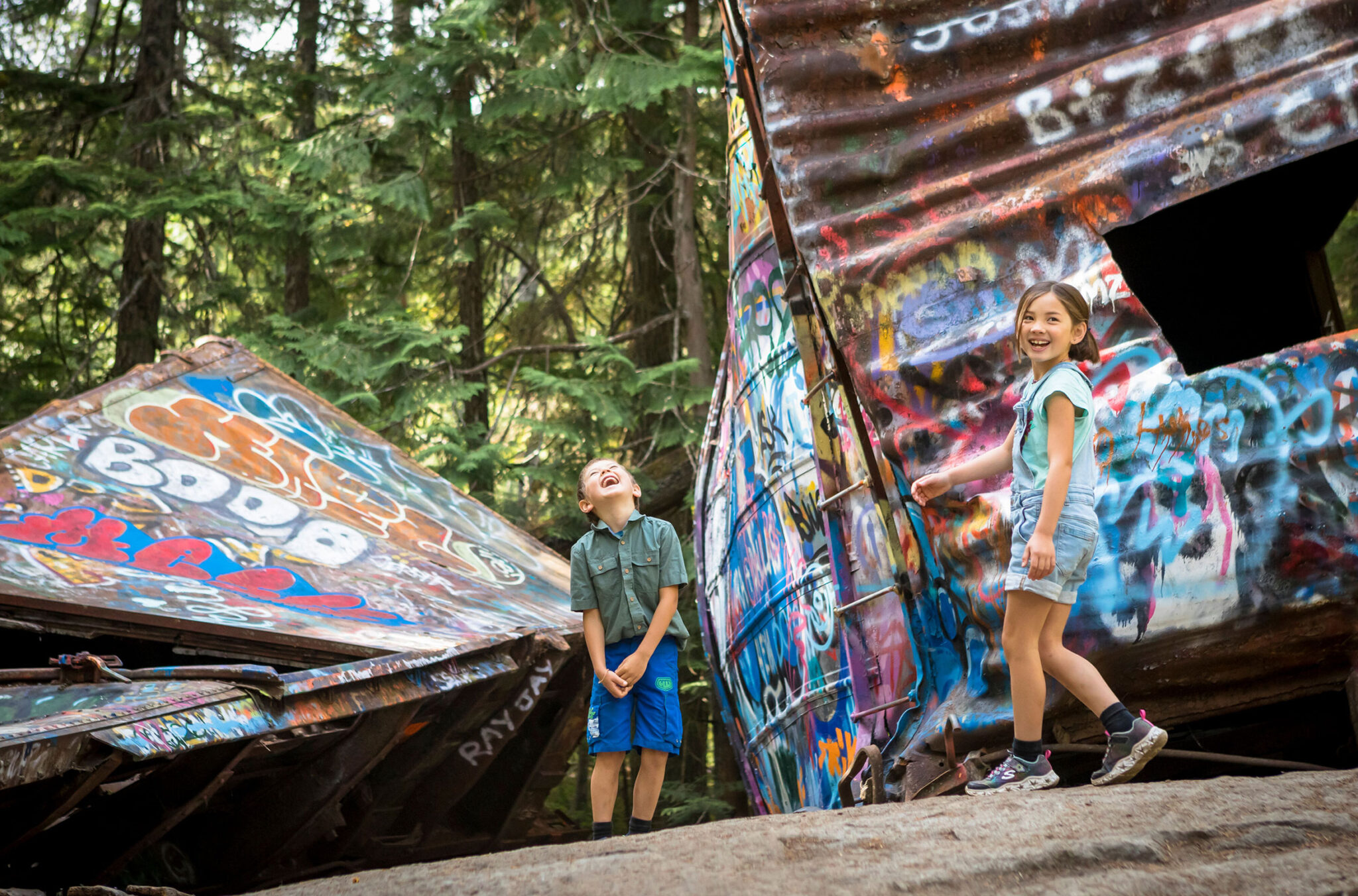 Two kids explore the train wreck in Whistler.