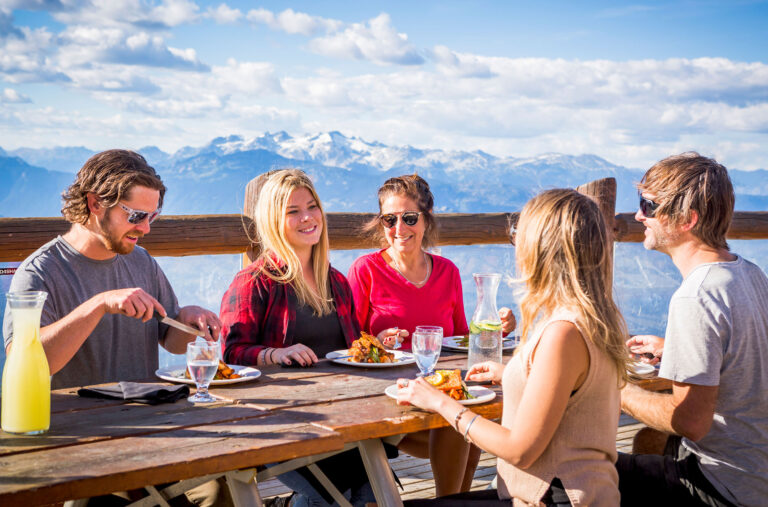 A group of friends enjoy a salmon bake dinner at 6,000 feet on Whistler Mountain.