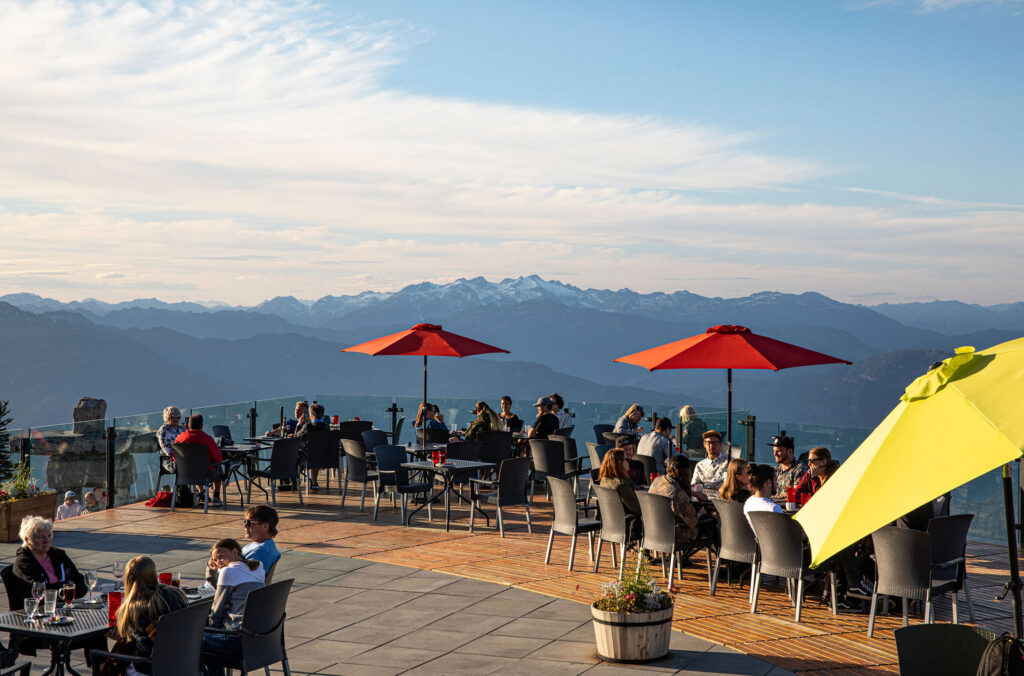 People sit on the open patio of the Roundhouse Lodge on Whistler Mountain for the Mountain Feast.