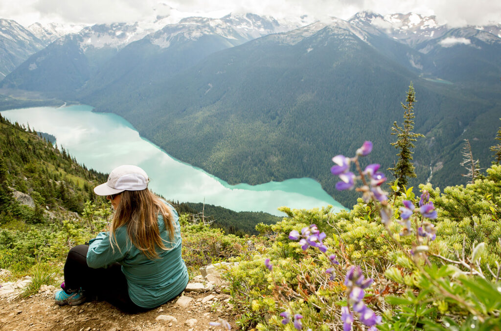 A hiker look out over the view of Cheakamus Lake on the High Note trail on Whistler Blackcomb.