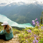 A hiker look out over the view of Cheakamus Lake on the High Note trail on Whistler Blackcomb.