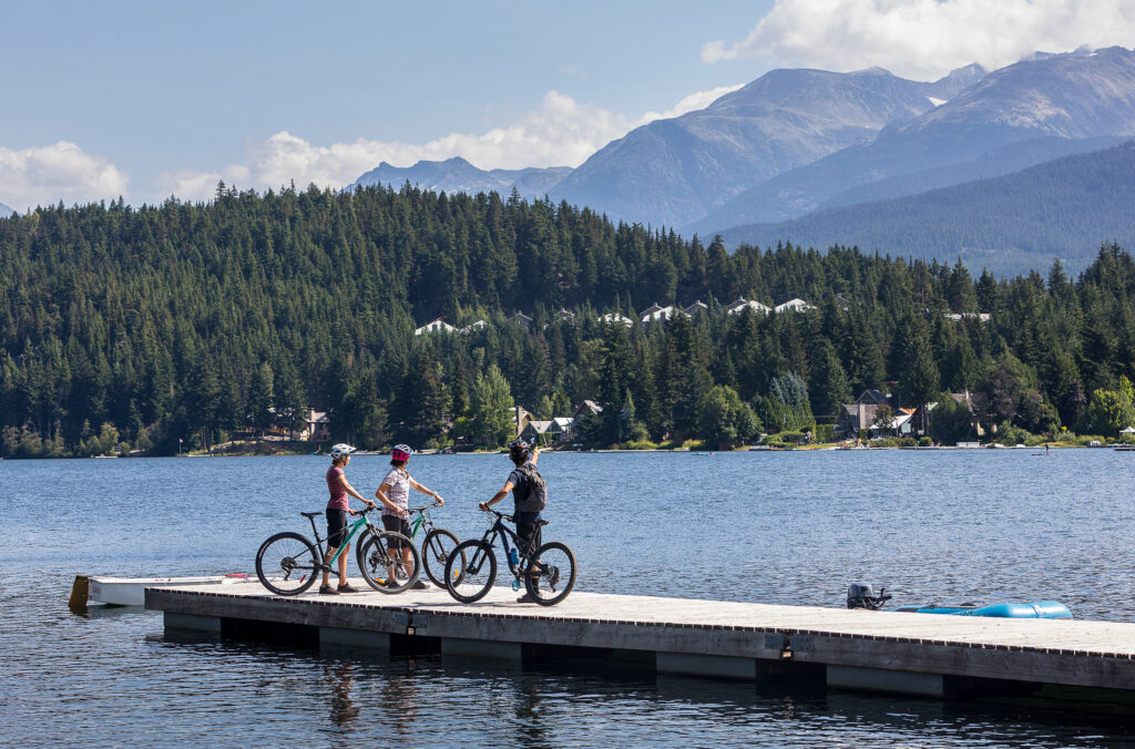 Bikers top with their guide to look out over Alta Lake on the Bike and Boat tour with Whistler Eco Tours.