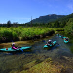 Kayakers follow their guide down the River of Golden Dreams in Whistler on a Bike & Boat tour.