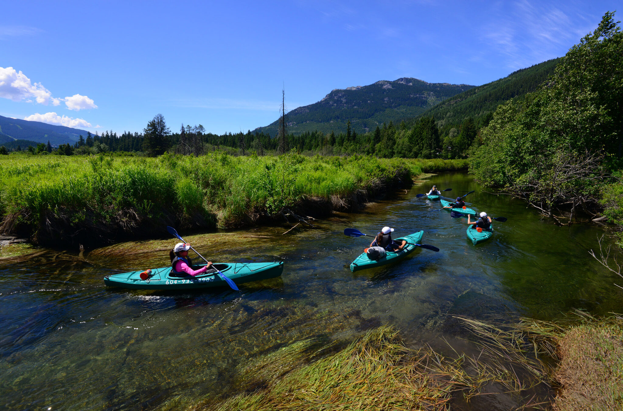 Kayakers follow their guide down the River of Golden Dreams in Whistler on a Bike & Boat tour.