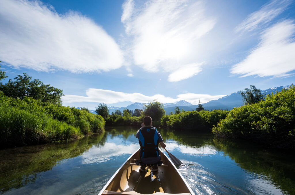 A canoeist places his paddle in the waters at the entrance of the River of Golden Dreams in Whistler..