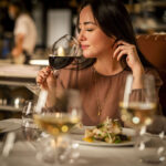 A woman savours her wine while dining at the Bearfoot Bistro in Whistler.