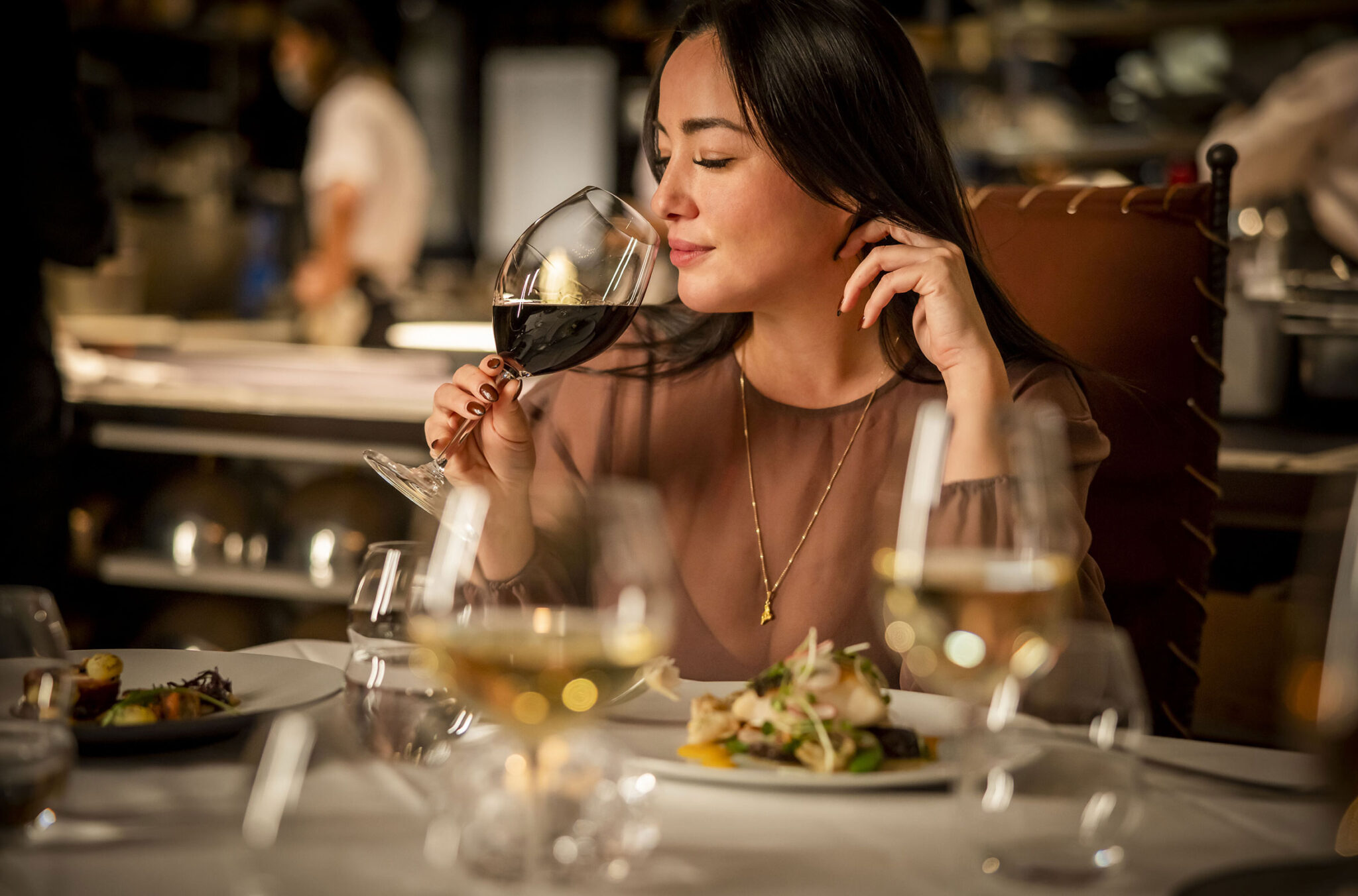 A woman savours her wine while dining at the Bearfoot Bistro in Whistler.