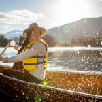 Paddler in a canoe splashes water on Alta Lake in Whistler
