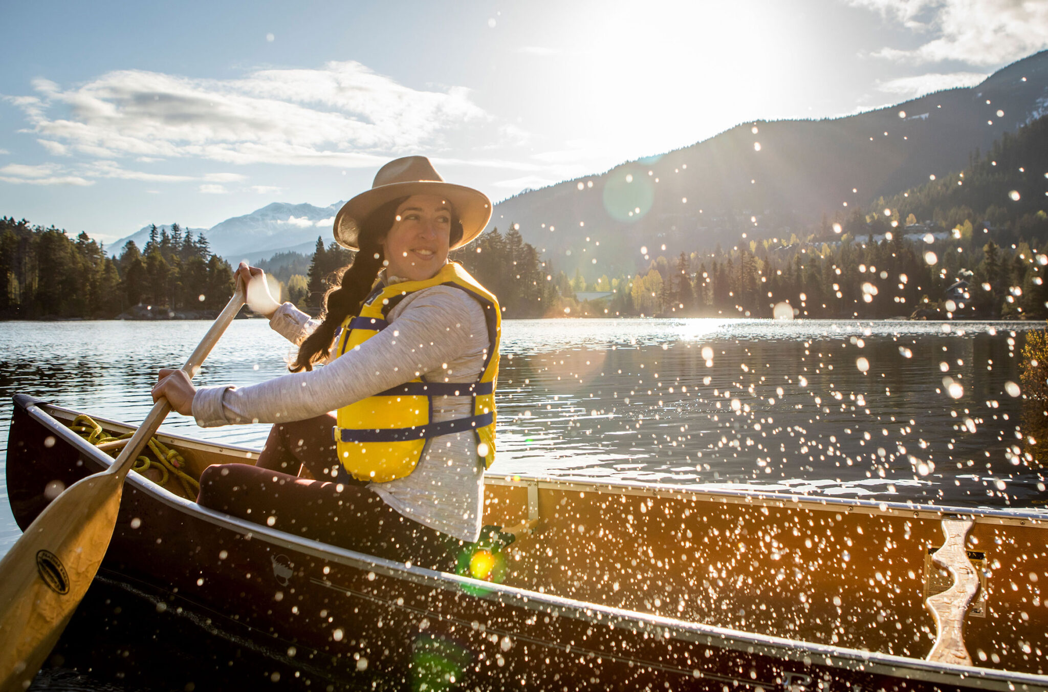 Paddler in a canoe splashes water on Alta Lake in Whistler
