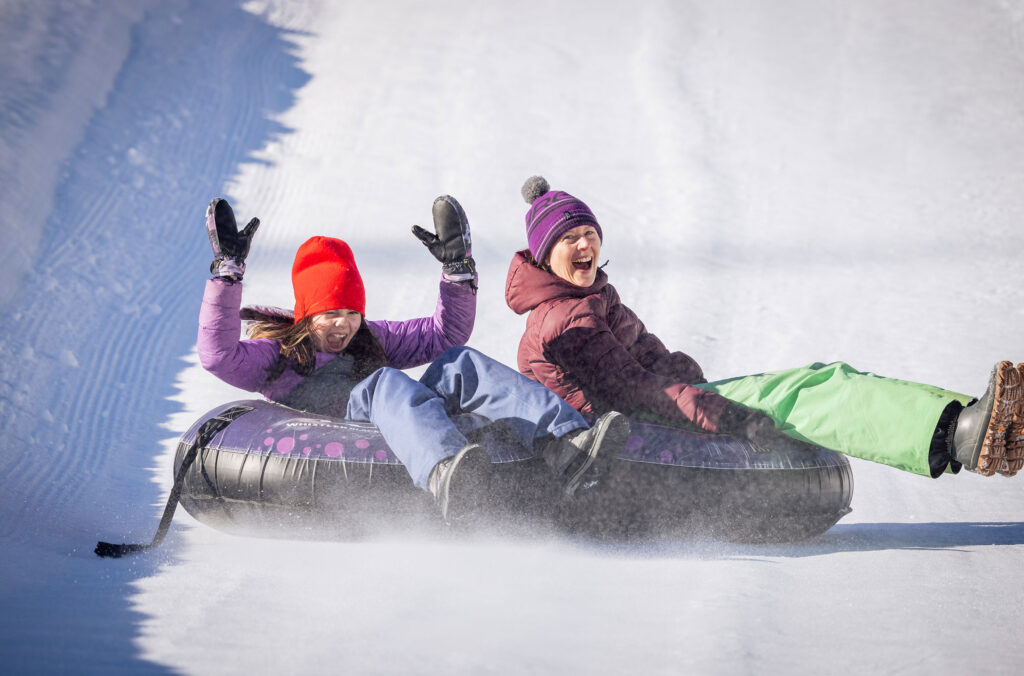 A mother and daughter spin down the ice at the Tube Park on Whistler Mountain.