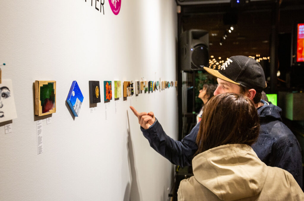 People look at the teeny tiny artworks at The Gallery in Whistler.