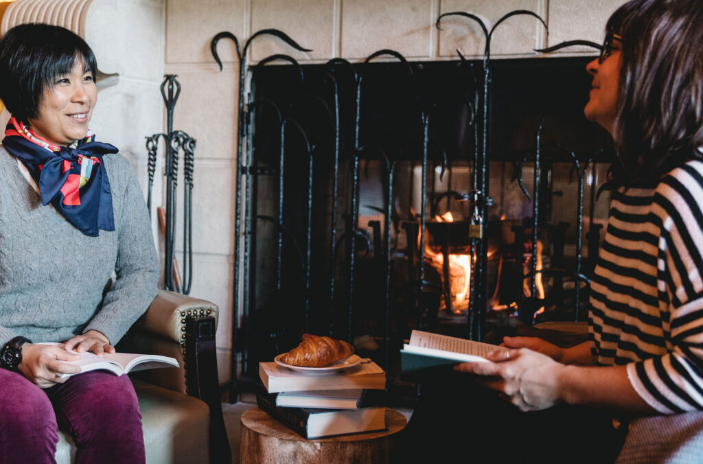 Two women read in front of the fire at the Whistler Writers Festival.