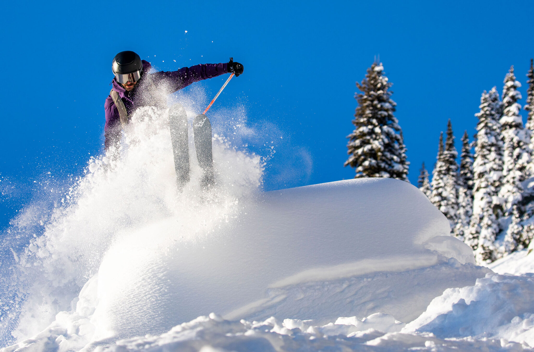 A skier powers over a fluffy, powder pillow on Whistler Blackcomb.