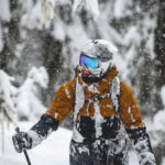 A skier is covered in snow as they enjoy the powder while skiing on Whistler Blackcomb.