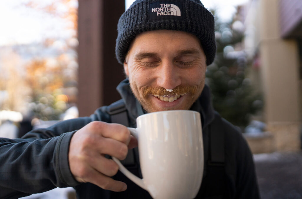 A man laughs after getting whipped cream in his moustache while drinking a hot chocolate at Blenz in Whistler.