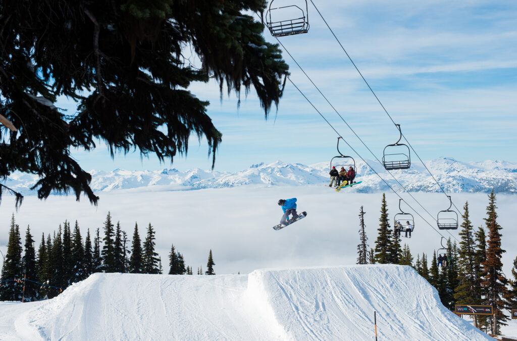 A snowboarder hucks off a jump on the terrain park on Whistler Blackcomb.