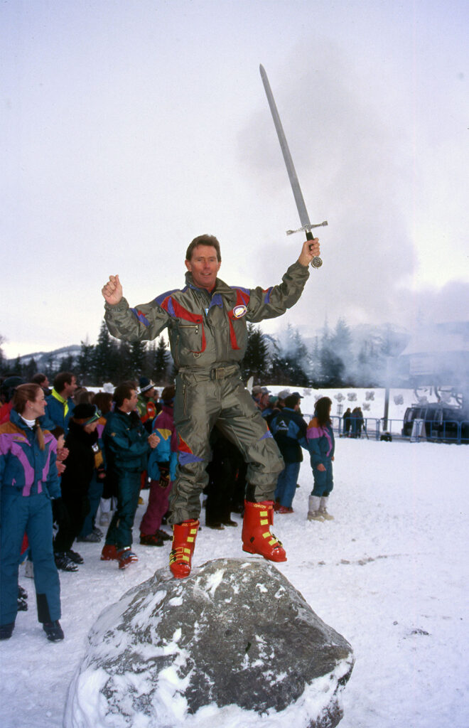 A photo of then-mayor, Ted Nebbing, at the opening of the Excalibur Gondola in 1994 where he's pulling a sword out of a stone.